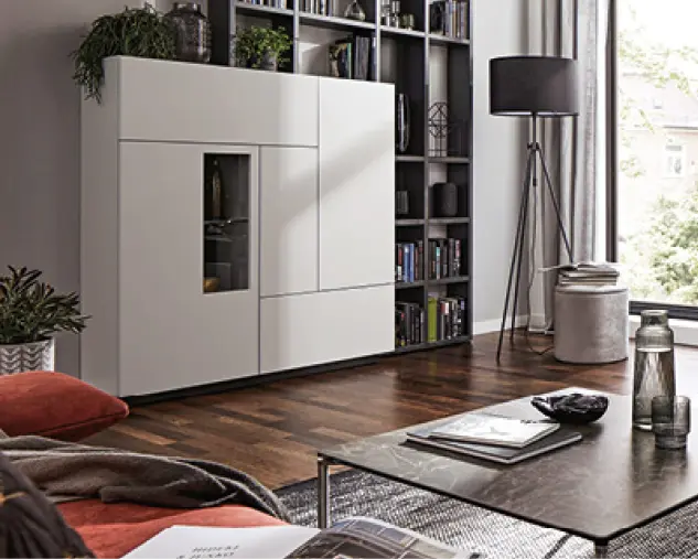 Stilvolles Wohnzimmer mit Wohnwand aus Massivholz, hellem Sofa, Lowboard und Couchtisch. Ein brauner Ledersessel setzt Akzente. Moderne Wohnzimmermöbel aus Holz sorgen für zeitlose Einrichtung im natürlichen Design.